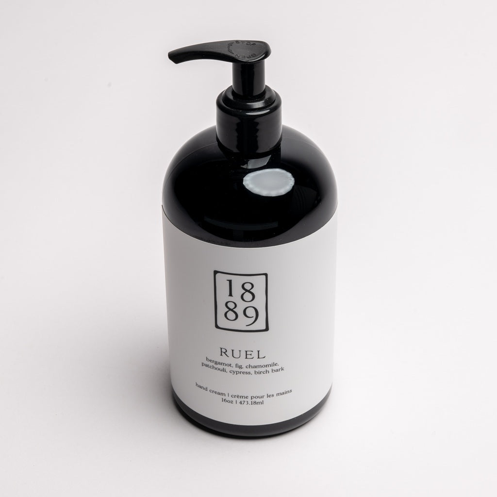 A black pump bottle of RUEL hand cream with a white label, photographed on a clean white background.