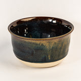 Black ceramic bowl with yellow accents on a white background