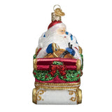 Decorative Christmas ornament of Santa Claus in a sleigh with gifts on a white background