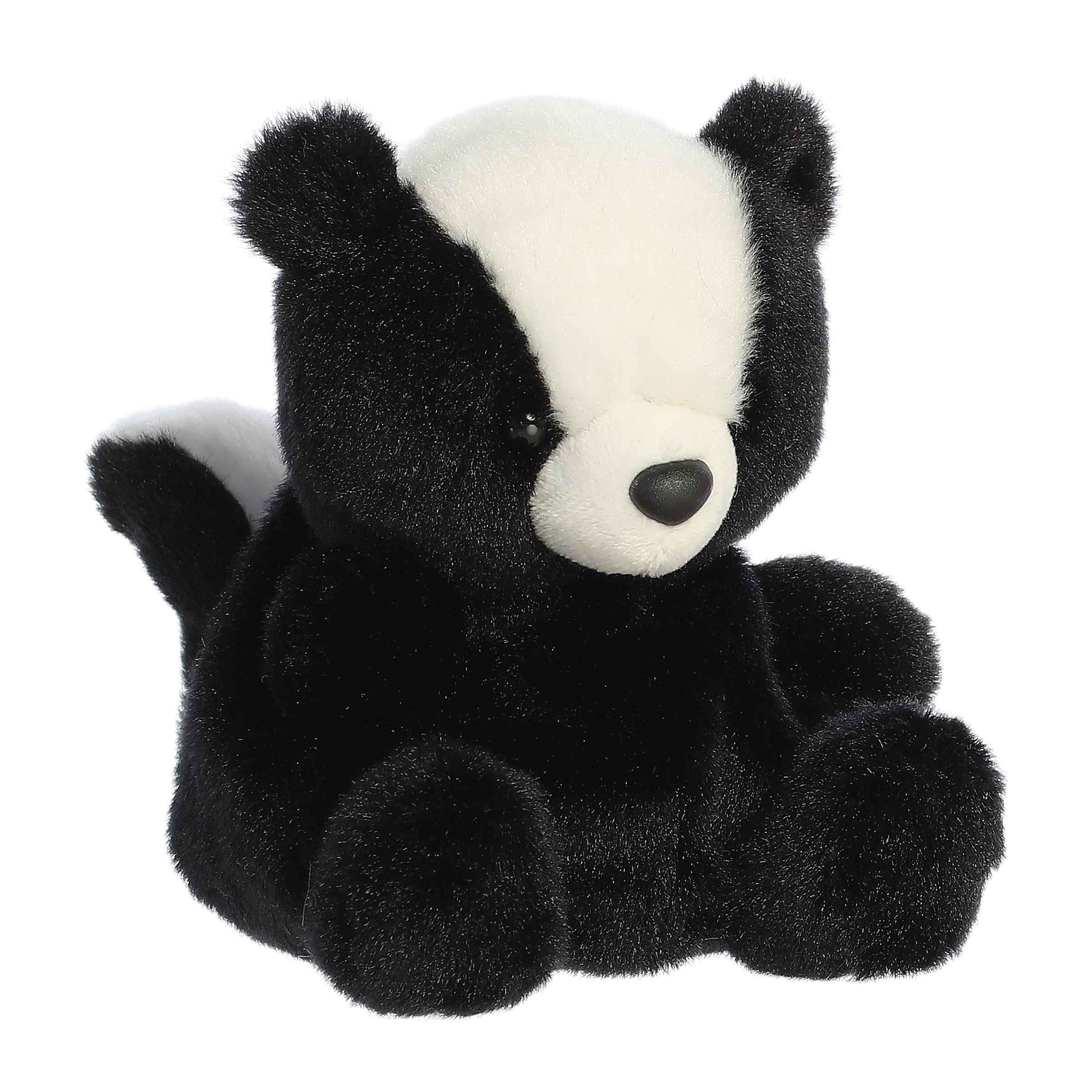 A black and white plush skunk toy sitting against a plain white background.