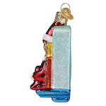 Christmas ornament with an elf by a decorated tree on a white 