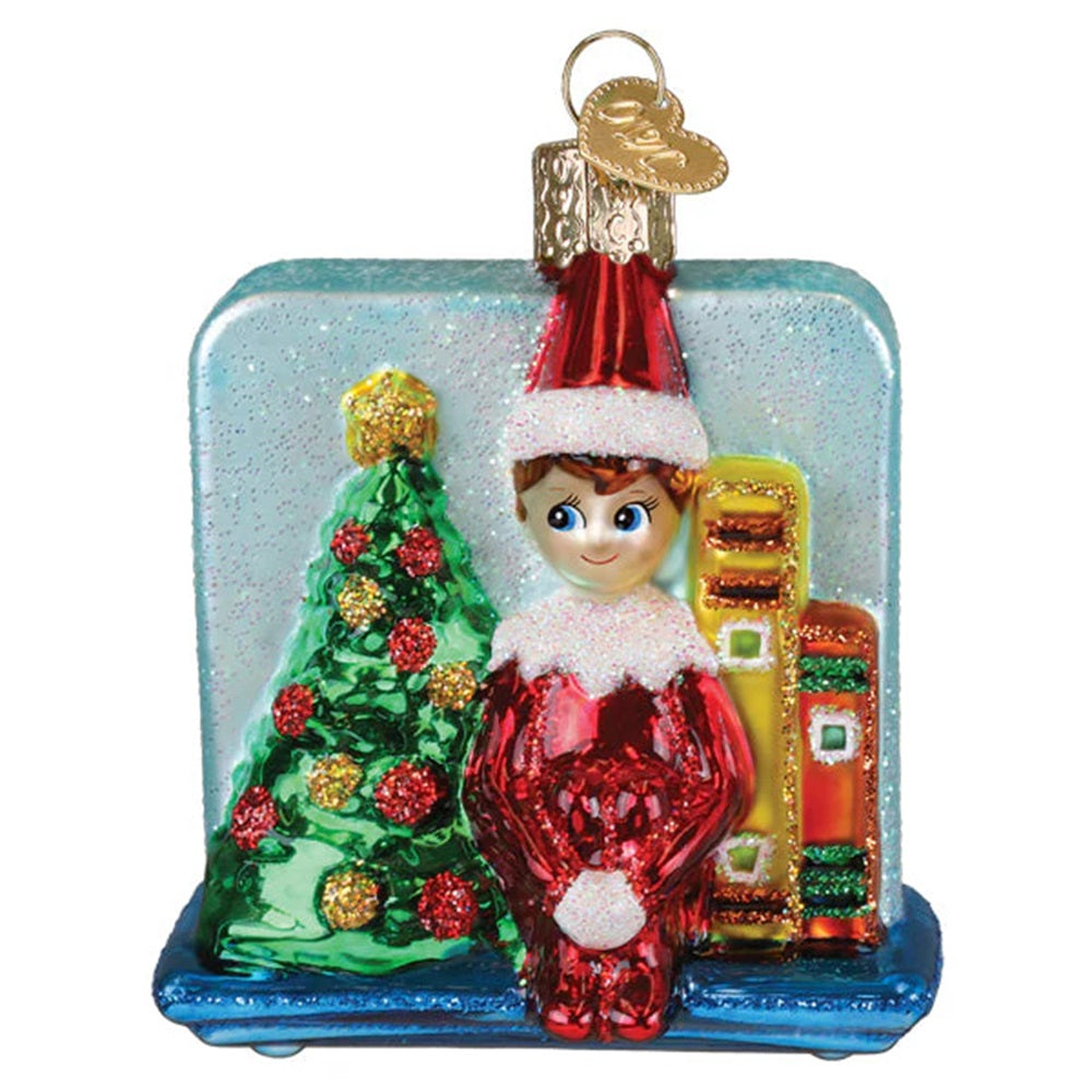 Christmas ornament with an elf by a decorated tree on a white background