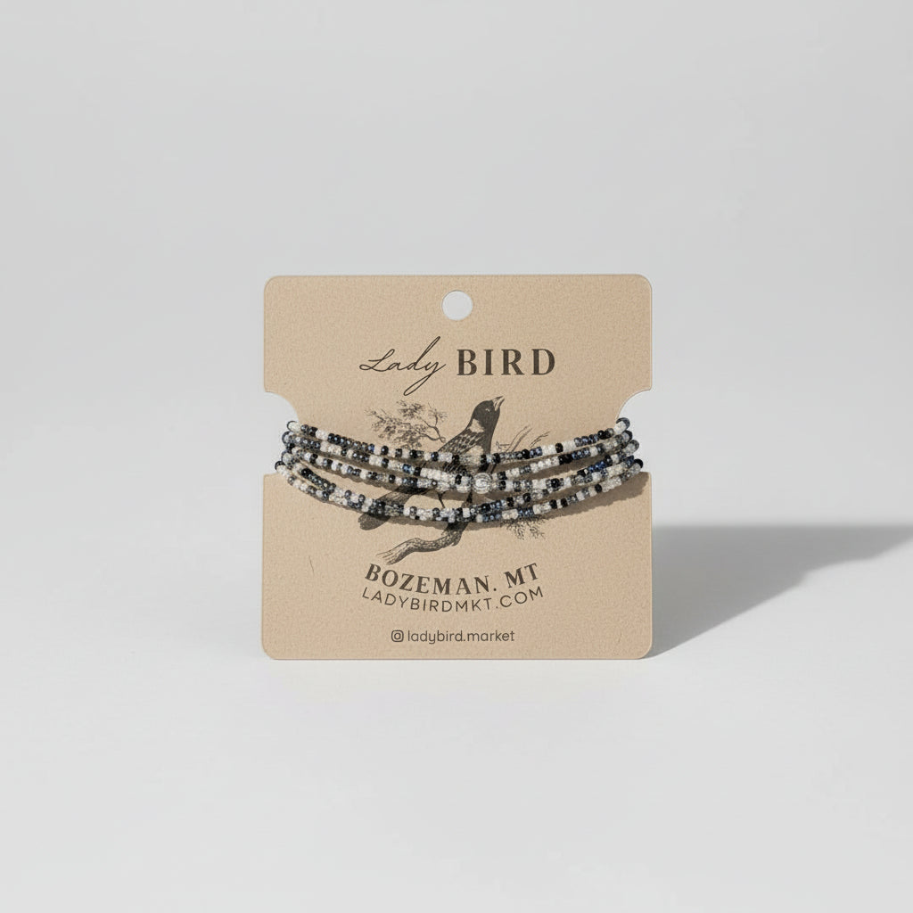 Set of beaded bracelets on a 'Lady Bird' branded card against a wooden background