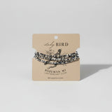 Set of beaded bracelets on a 'Lady Bird' branded card against a wooden background