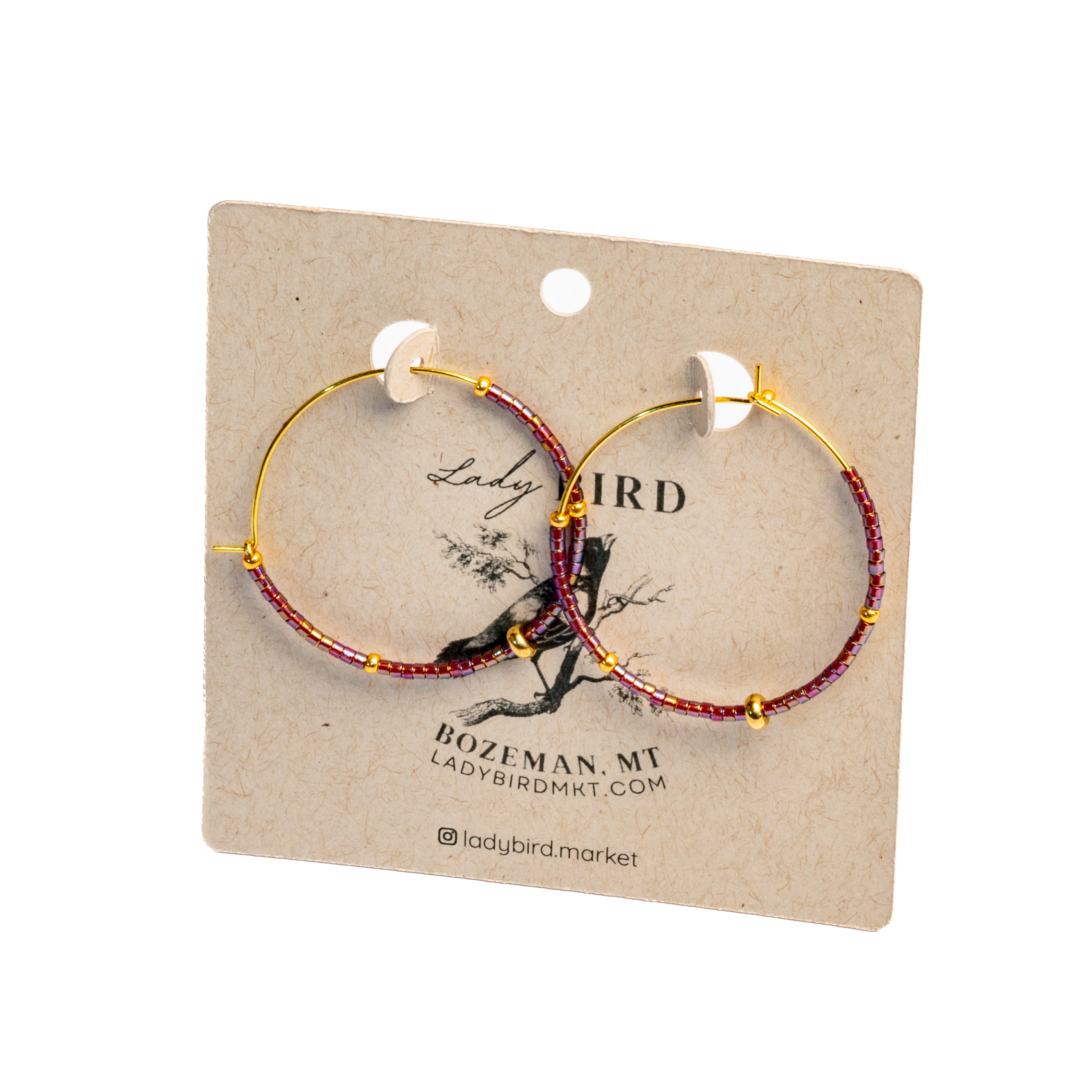 Two hoop earrings on a Lady Bird branded card with a white background