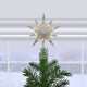 Decorative star tree topper on a Christmas tree with a snowy window background