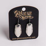Silver earrings on a 'Girl Run Away with the Spoon' branded card.