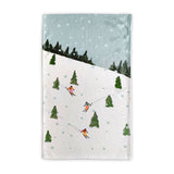 Tea towel with skiers and trees design on a white background