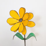 Yellow metal flower sculpture on a white background