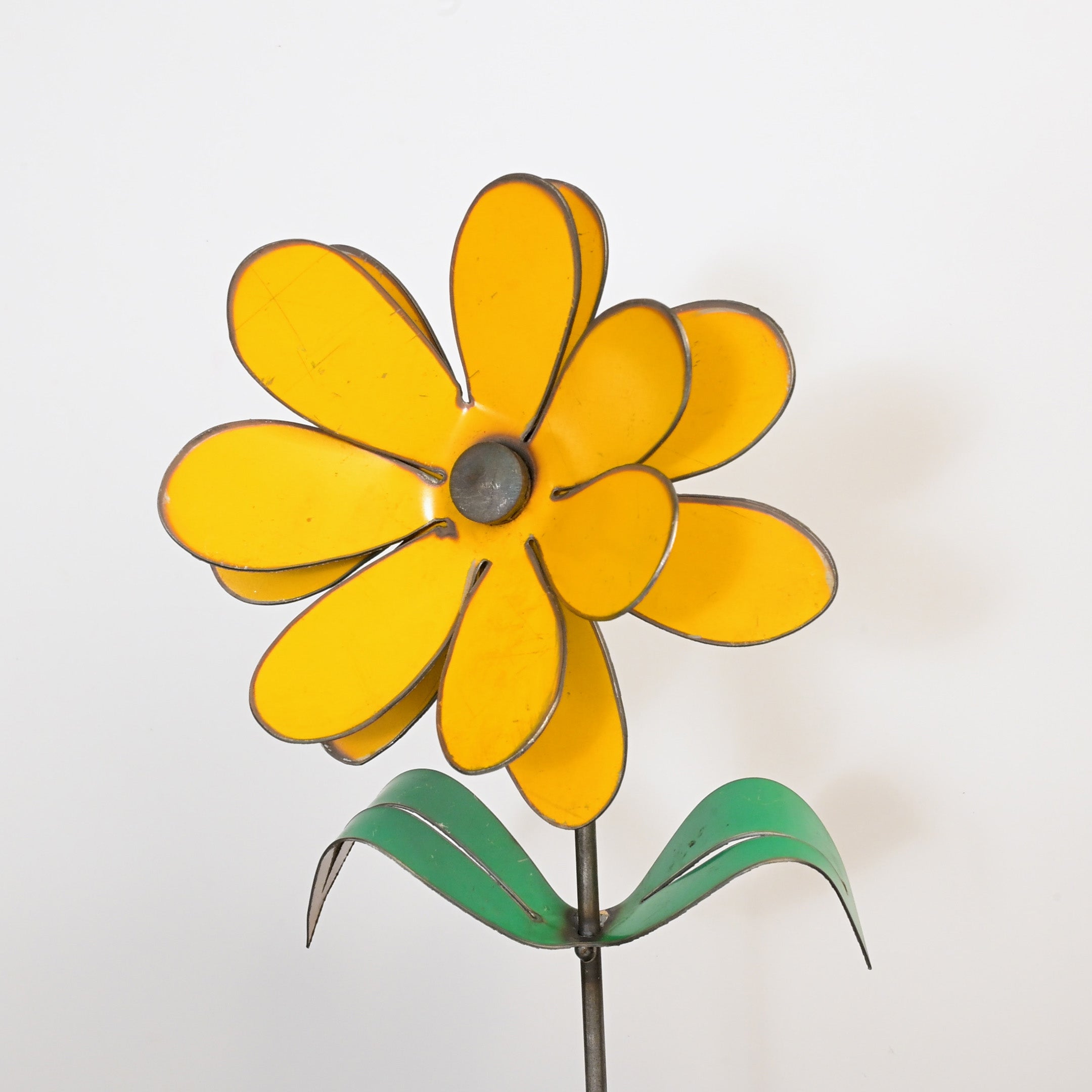 Yellow metal flower sculpture on a white background