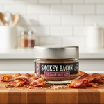 Jar of smoky bacon-infused sea salt on a wooden cutting board with bacon slices.