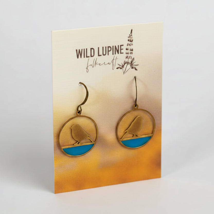 Earrings on a Wild Lupine Folkcraft branded card with a gradient background