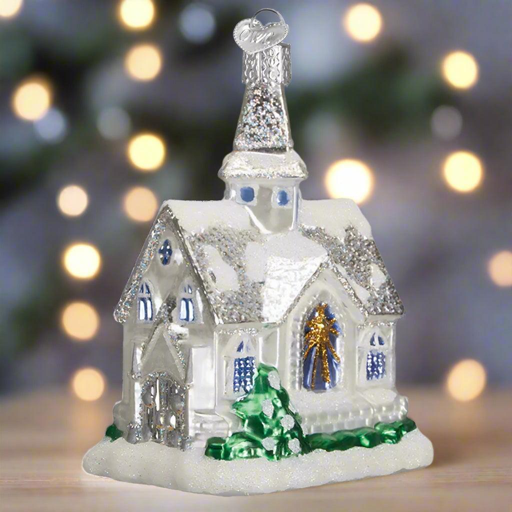 Decorative glass house ornament with a steeple on a white background