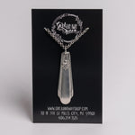 Silver pendant necklace on a black card with branding and contact information.
