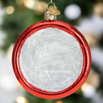 Round red glass ornament with white center on a white background