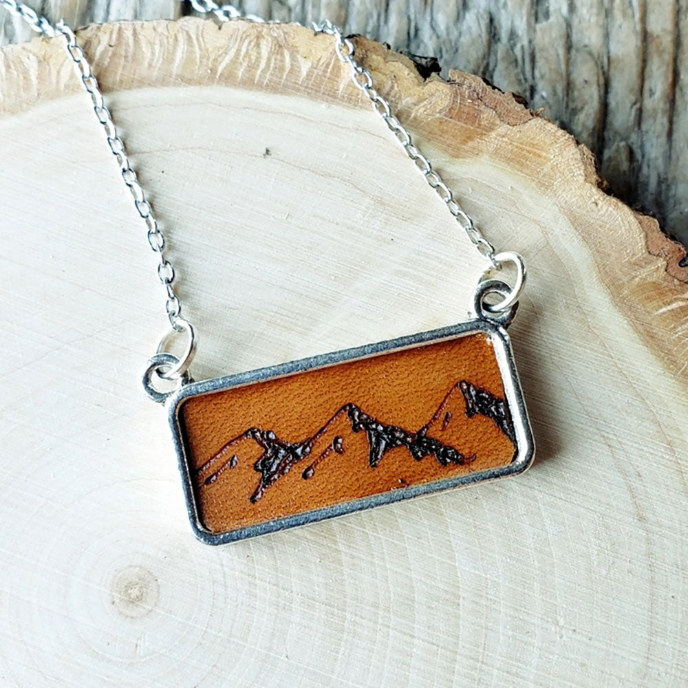 Necklace with a mountain design on a wooden surface