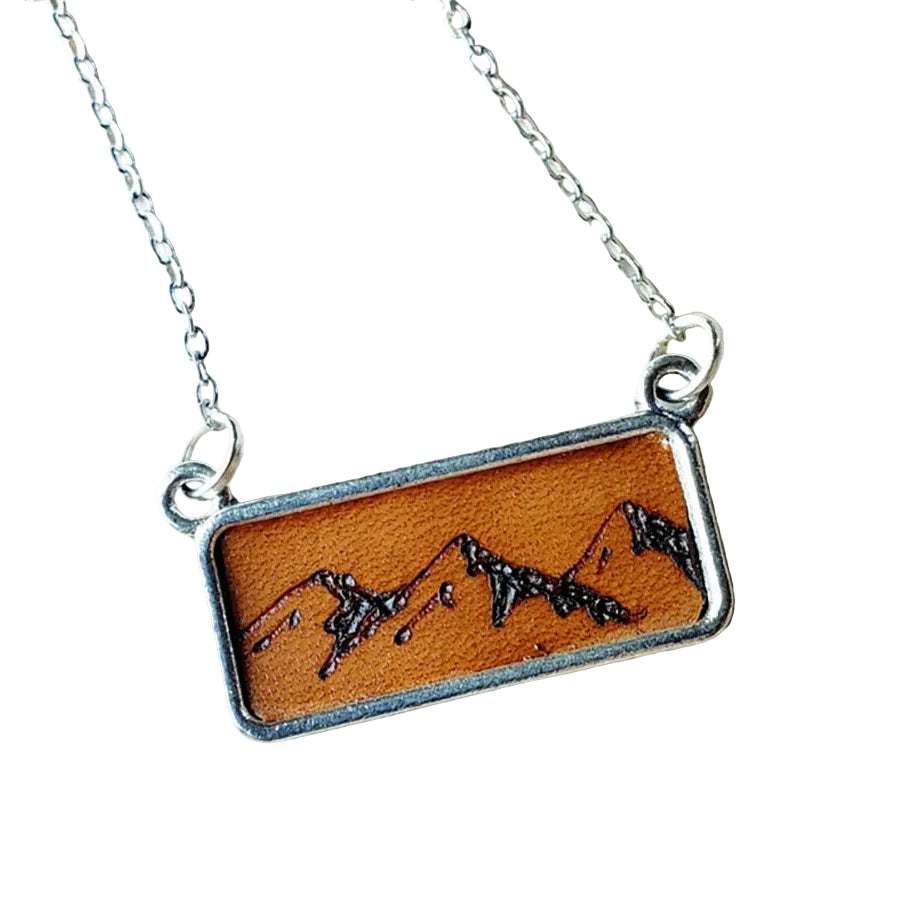 Necklace with a mountain design on a wooden surface
