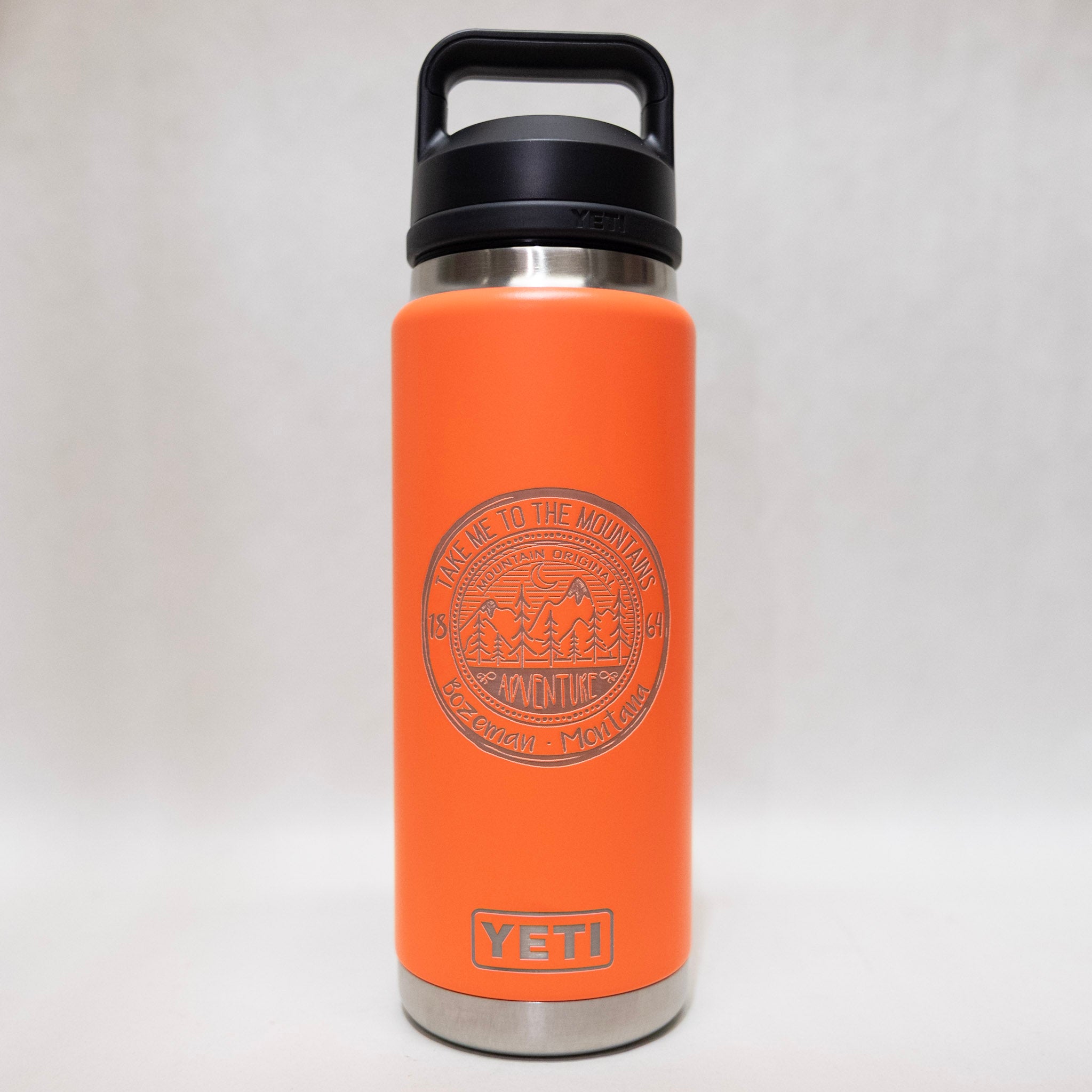 Orange YETI water bottle with a black lid on a white background