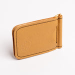 A tan leather money clip wallet with gold-tone metal hardware, black contrast stitching, and an embossed lion logo on the front, shown on a clean white background.