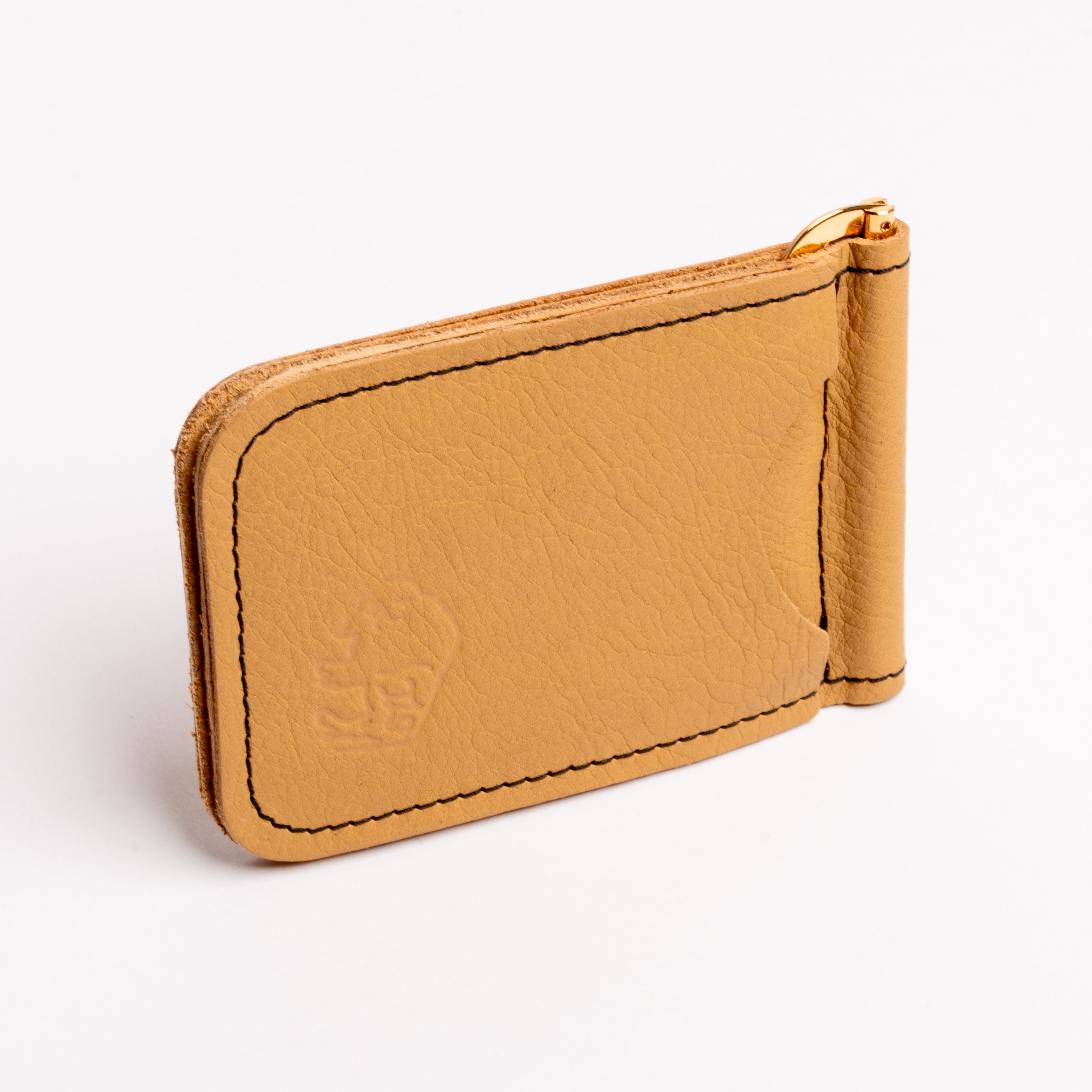 A tan leather money clip wallet with gold-tone metal hardware, black contrast stitching, and an embossed lion logo on the front, shown on a clean white background.