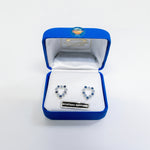 Heart-shaped earrings in a blue jewelry box with 'Montana Sapphire' label.