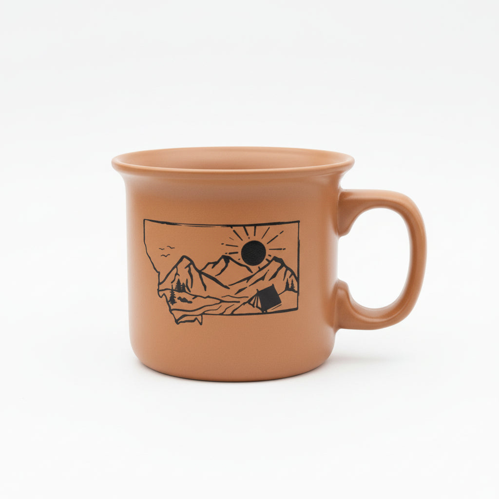 Ceramic mug with mountain and sun design on a white background