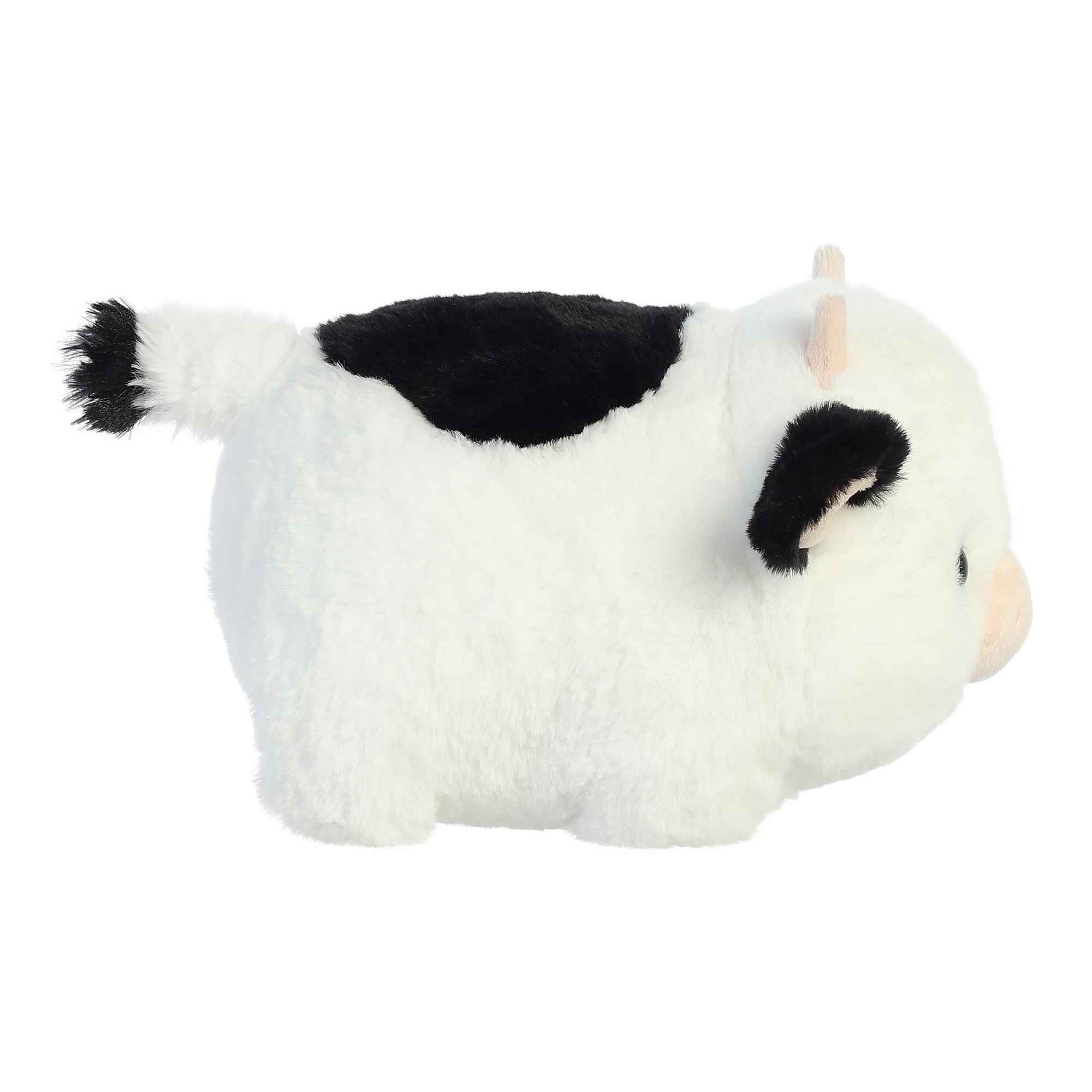 Plush toy cow with black spots on a white background