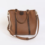 Brown leather handbag with a shoulder strap on a white background