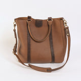 Brown leather handbag with a shoulder strap on a white background