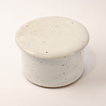 Speckled ceramic container on a white background