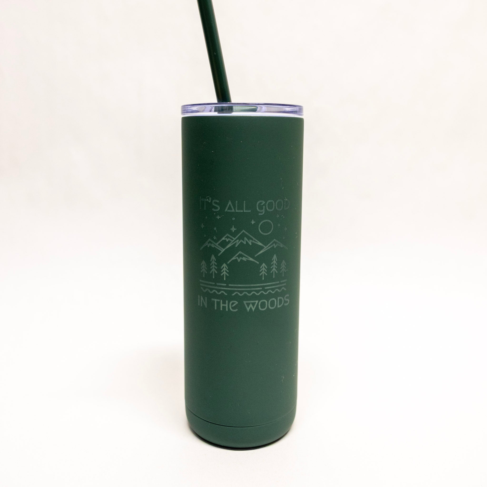 Green tumbler with 'It's All Good in the Woods' text and mountain design on a white background