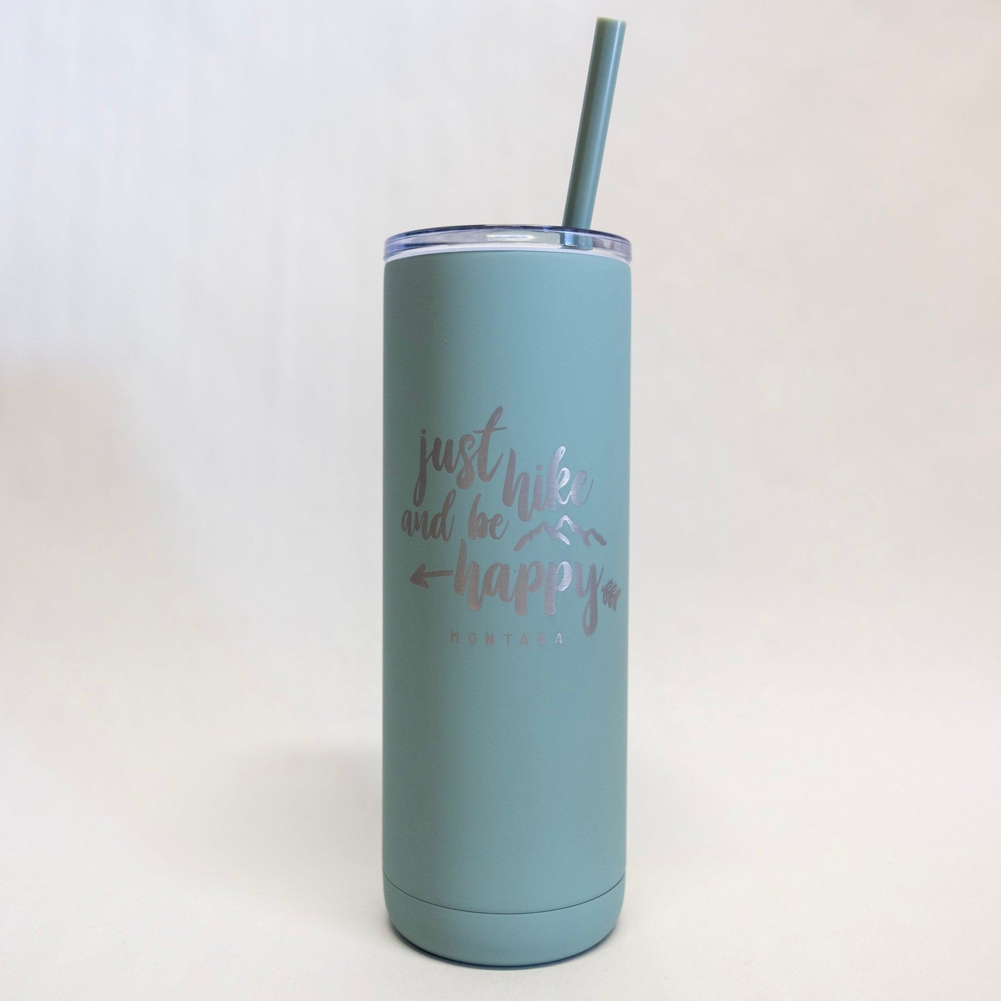 Blue tumbler with 'just hike and be happy' text on a white background