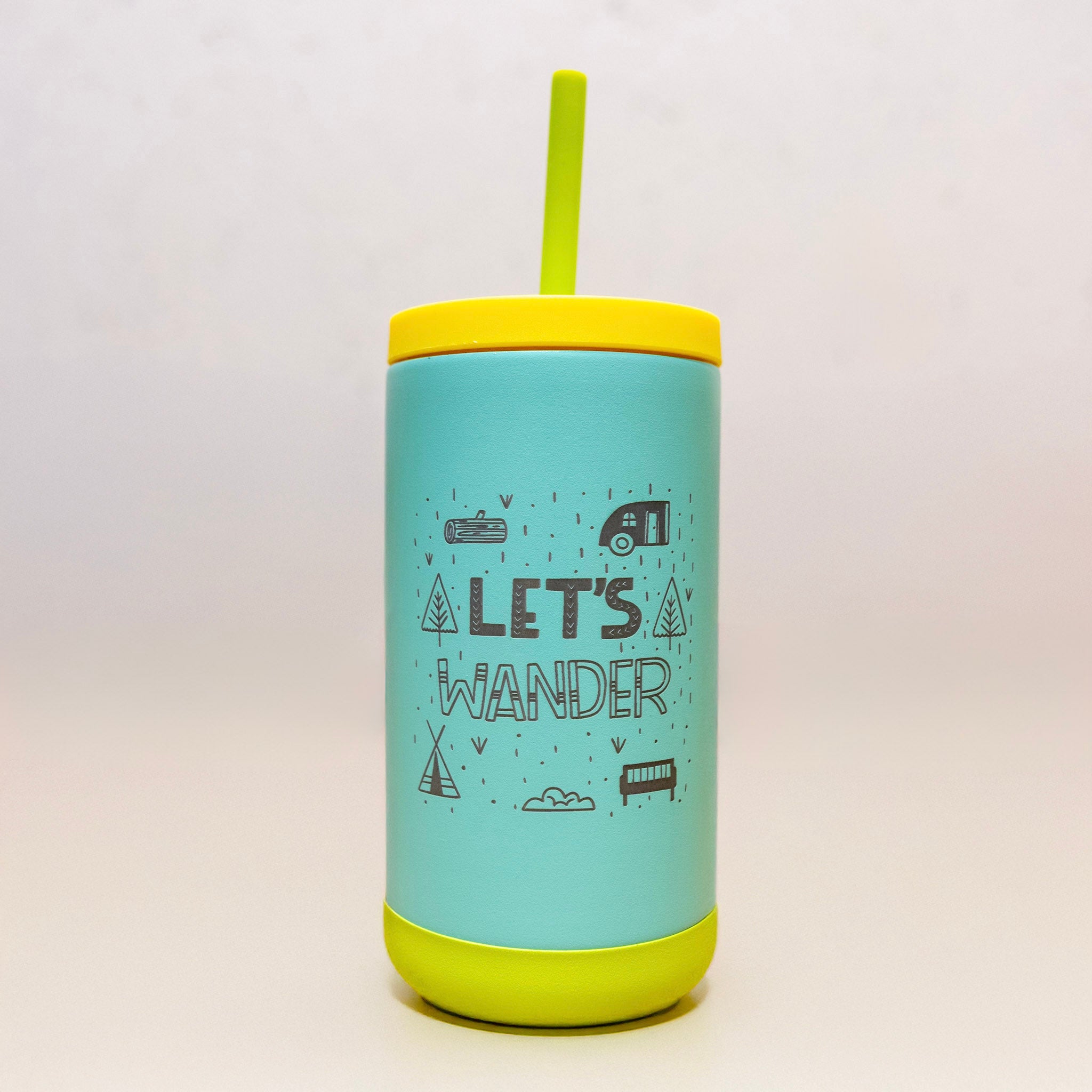 Turquoise tumbler with yellow lid and straw on a wooden surface