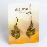 Pair of leaf-shaped earrings on a Wild Lupine Felicraft branded card.