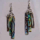 A close up of abalone shell earrings, showing the blue, purple, and green coloring of each earring.