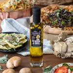 Olivelle Wild Mushroom & Sage infused olive oil bottle on a wooden table with food items and ingredients.