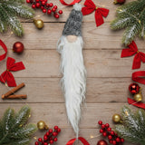 Felted wool gnome with long white beard and patterned hat.