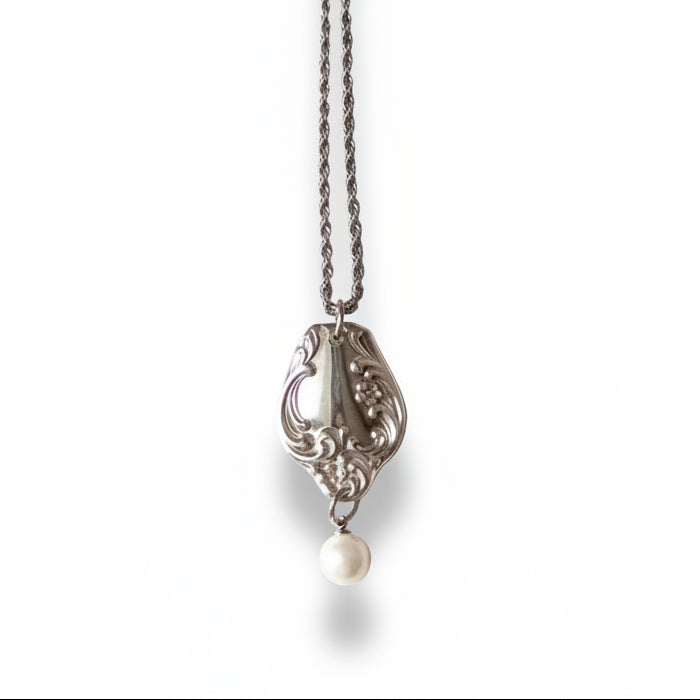 Silver necklace with a pendant on a light gray background