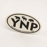 An oval Yellowstone National Park sticker featuring black silhouettes of a bear, moose, and bison above the large letters 'YNP', with 'YELLOWSTONE NATIONAL PARK' curved along the bottom border, shown on a clean white background.