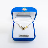 A yellow gold V-shaped necklace with Montana Sapphire stones displayed in an open blue jewelry box with a white lining.