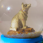 Snow globe with wolf design and 'Yellowstone National Park' base on a white background