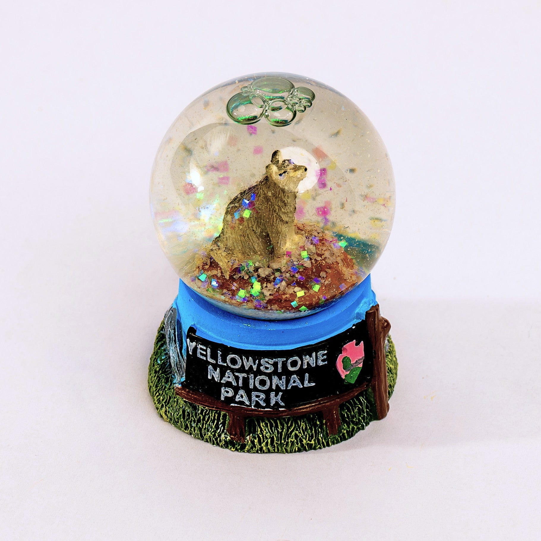 Snow globe with wolf design and 'Yellowstone National Park' base on a white background