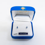 Yogo Sapphire earrings in a blue jewelry box on a white background