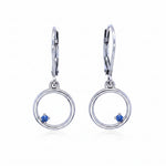Pair of silver earrings with circular design and blue montana yogo sapphires on a white background