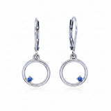 Pair of silver earrings with circular design and blue montana yogo sapphires on a white background