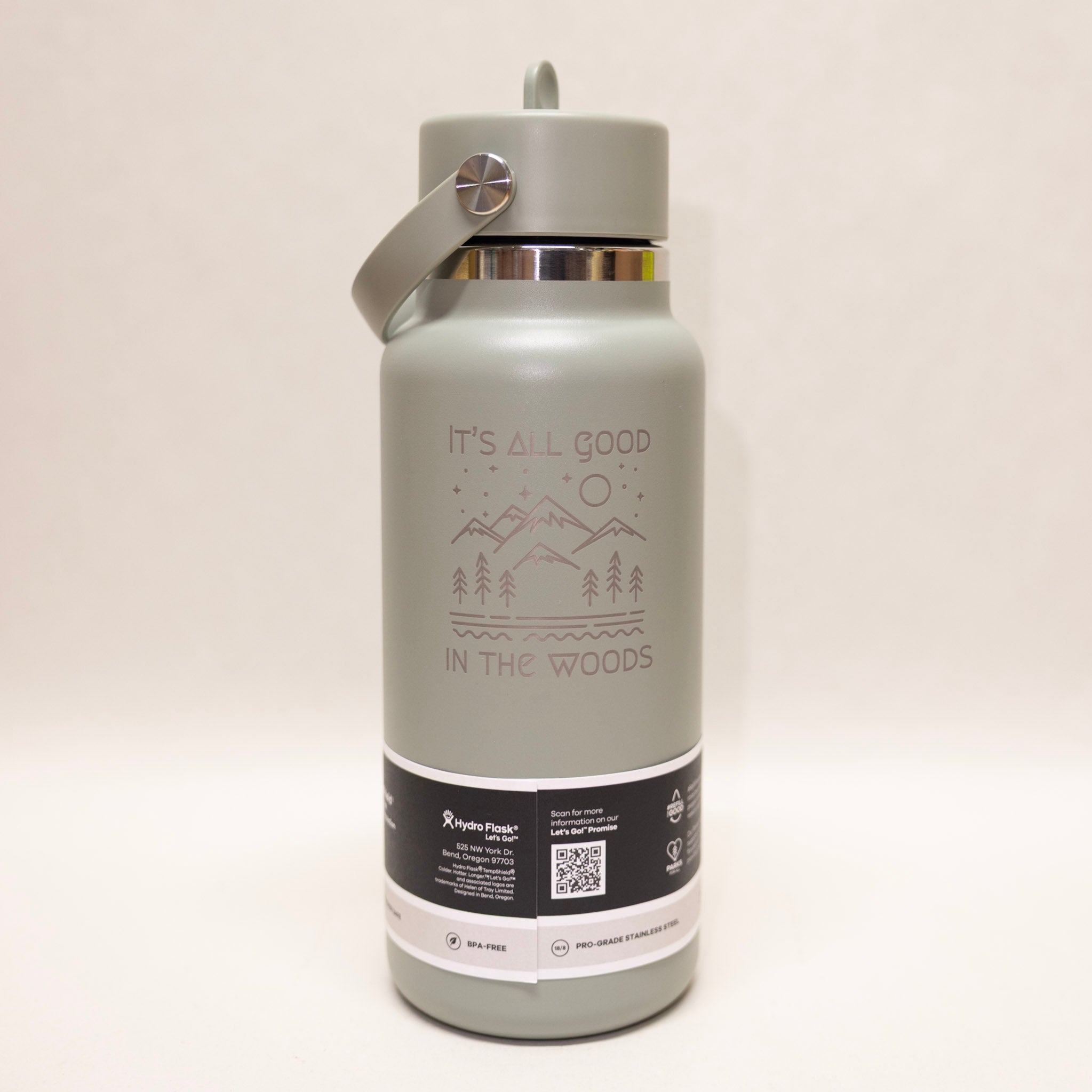 Gray water bottle with 'It's All Good in the Woods' text and mountain design on a white background