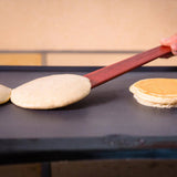 Person using a spatula to flip pancakes on a griddle.
