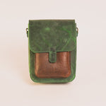 Green and brown leather crossbody bag on a white background