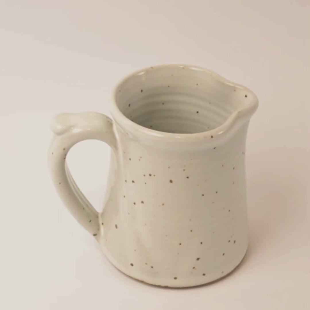 Video of a Speckled ceramic pitcher on a beige background