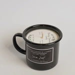 Black mug candle with 'Montana Farmhouse Candles' label on a white background